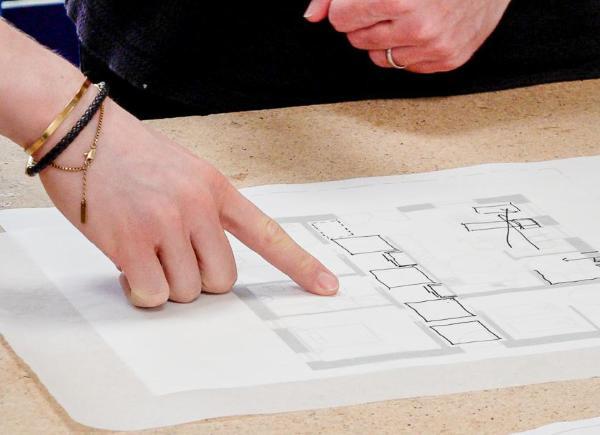 People pointing at some architecture design drawings