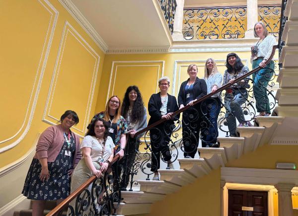 The chairs of BSU's staff networks pose together on a grand staircase