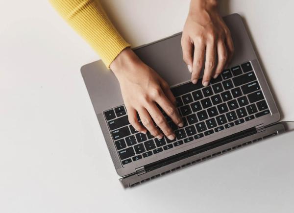 hands typing on laptop keyboard